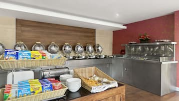 A buffet setup with various food items and containers.