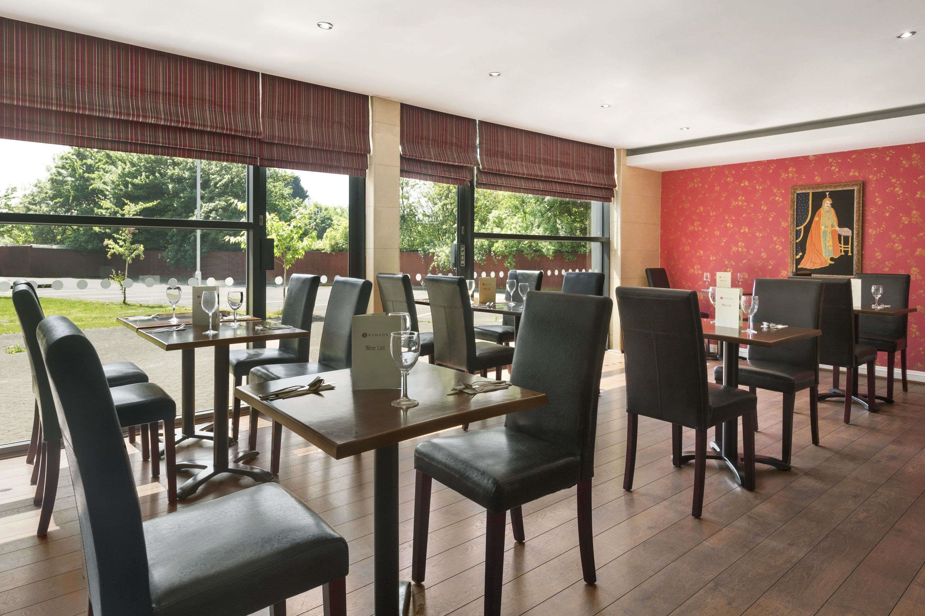 Un restaurant doté d’une longue table, de nombreuses chaises et d’une grande fenêtre donnant sur l’extérieur.