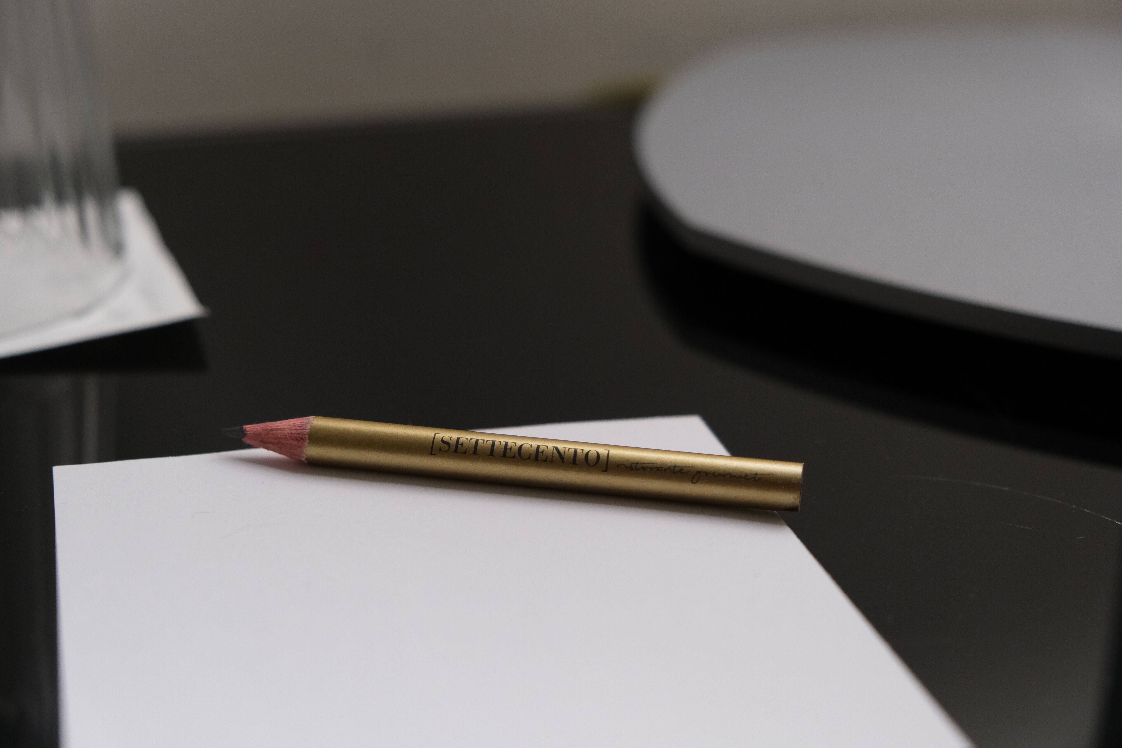 Un stylo de couleur or portant l’inscription « [SETTECENTO] » sur une surface blanche.