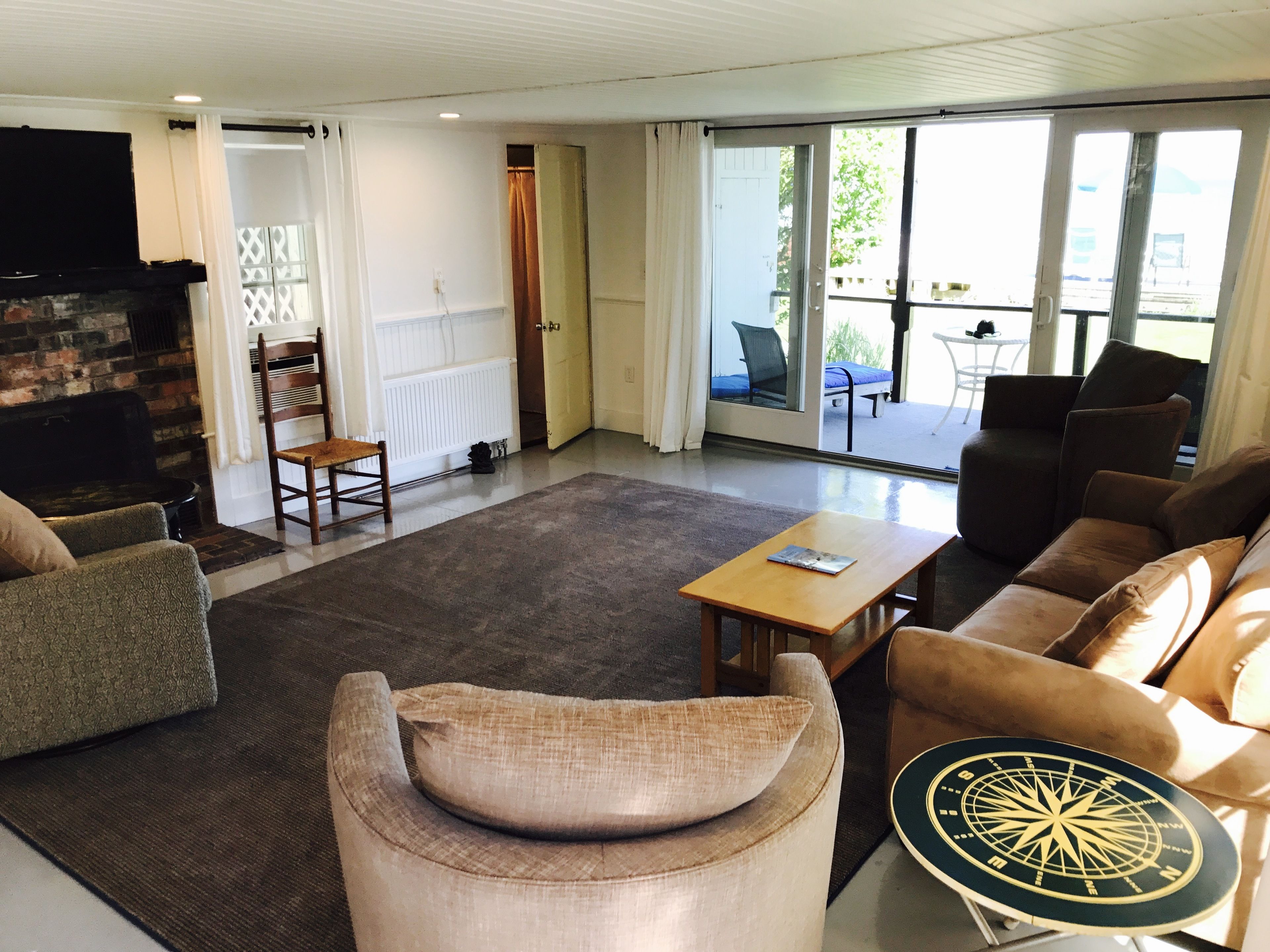 Un salon avec une cheminée, un canapé, une table basse et une vue sur l’extérieur grâce à une porte-fenêtre coulissante.