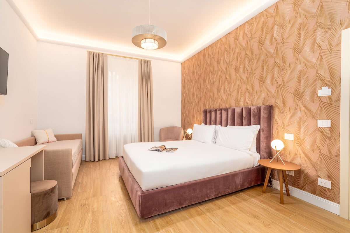 Una habitación de hotel moderna con una cama grande, un escritorio y una silla.
