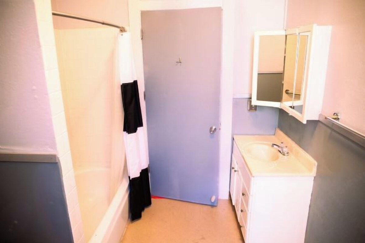 A bathroom with a shower, a sink, and a mirror.