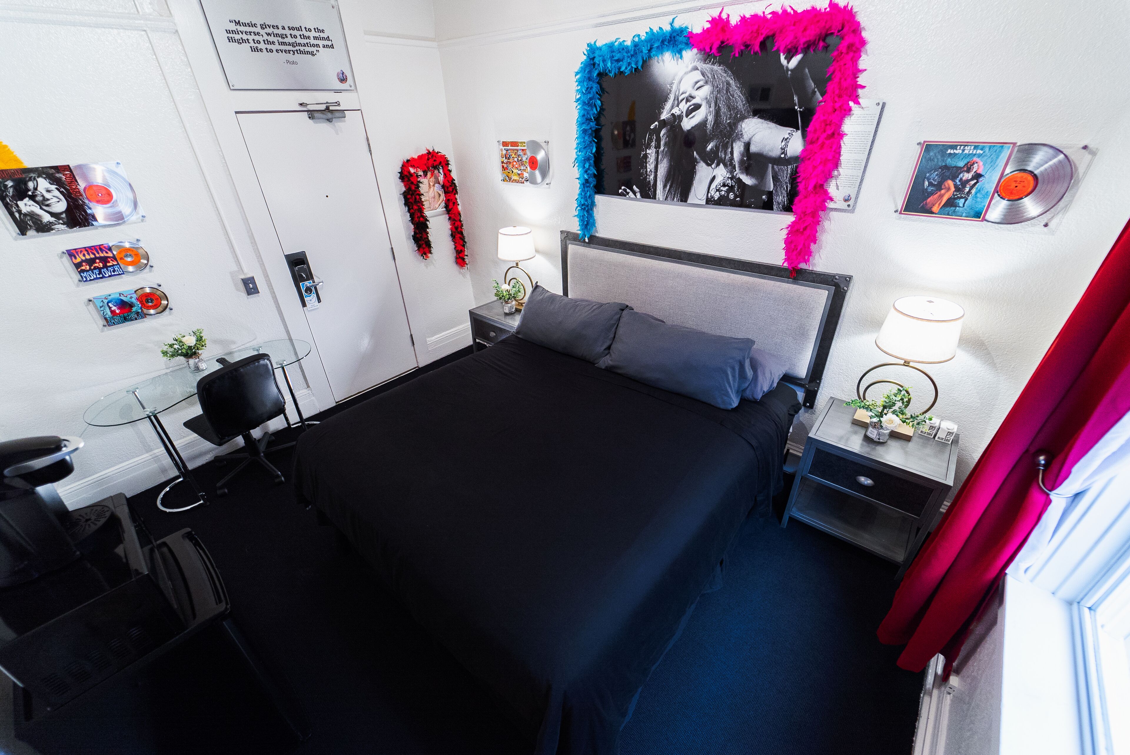 A bedroom with a bed, bedside tables, a desk, and a chair.