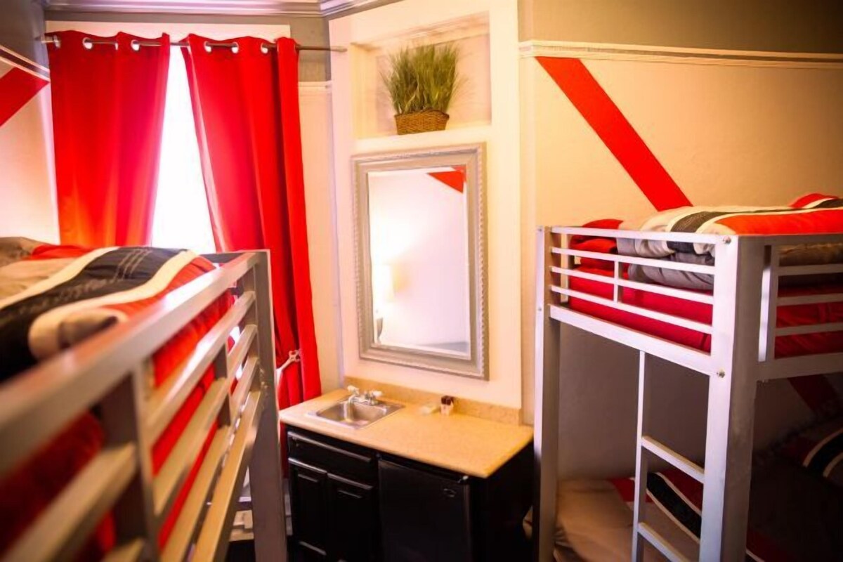 A bunk bed room with a sink and a mirror.