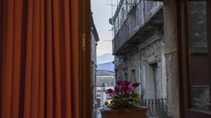 Une rue étroite d’où l’on aperçoit, au loin, des montagnes enneigées.