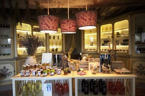 A wine tasting room with a variety of bottles displayed on shelves and a table with samples.