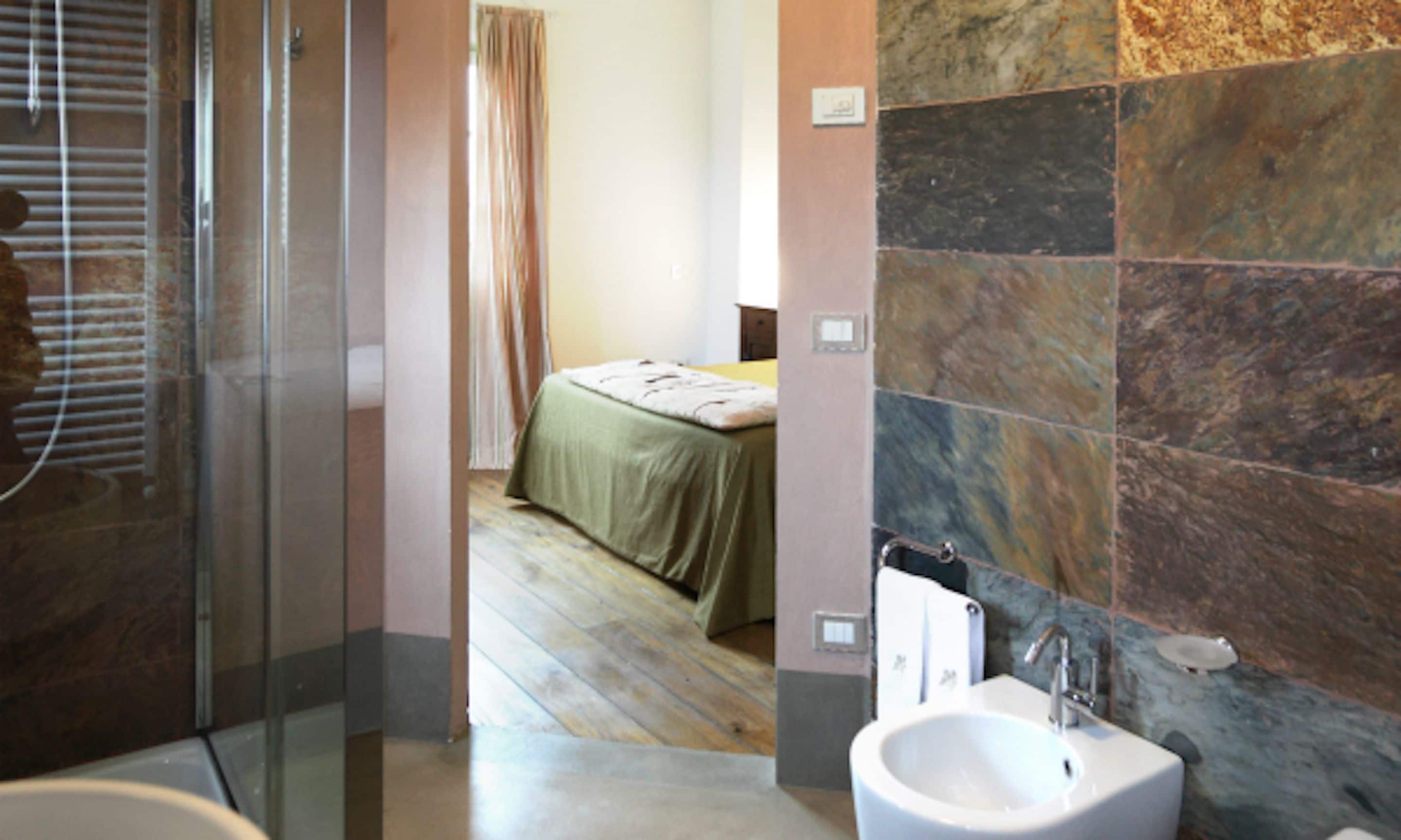 Bagno con vasca, lavabo e zona doccia.