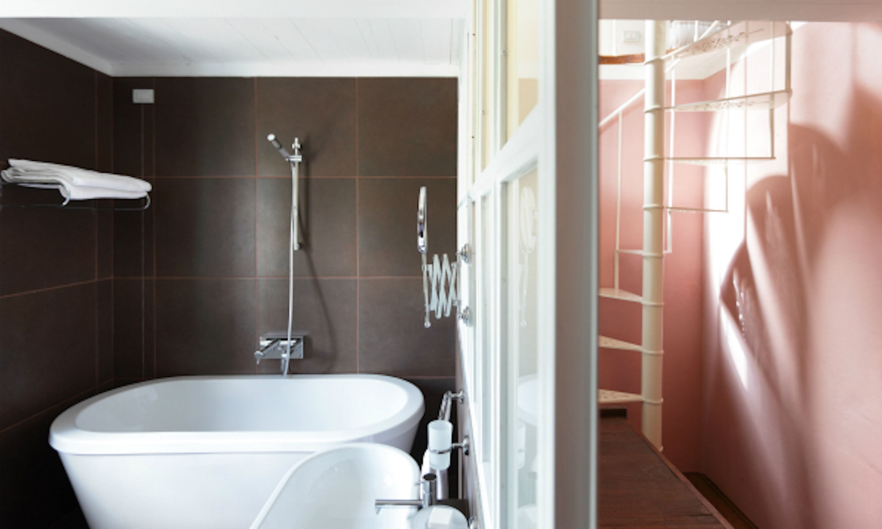 Un baño moderno con una bañera independiente, un cabezal de ducha y un inodoro.