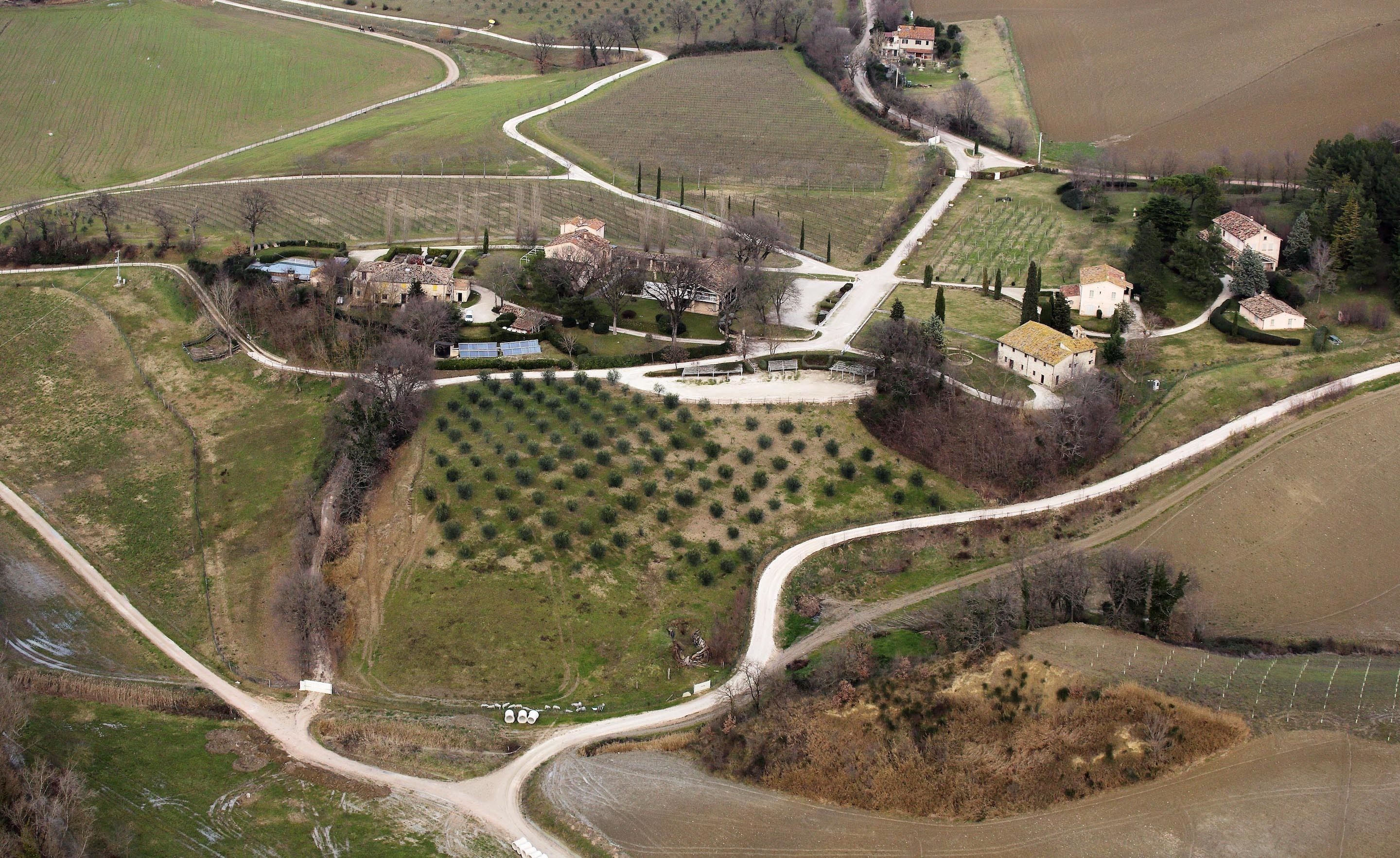 An aerial view of a rural area with winding roads, fields, and scattered houses.