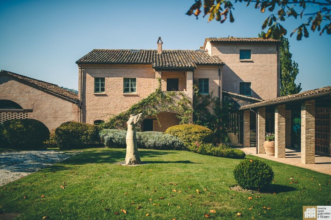 Un edificio tradicional con tejado de baldosas, un patio central y una estatua.