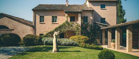 Un edificio tradicional con tejado de baldosas, un patio central y una estatua.