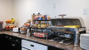 Una barra de buffet con diversos alimentos y utensilios.