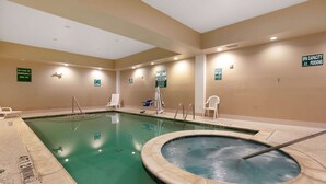 Ein Hallenbad mit Whirlpool, Badeaufsicht und Hinweisschild zur Spa-Kapazität.
