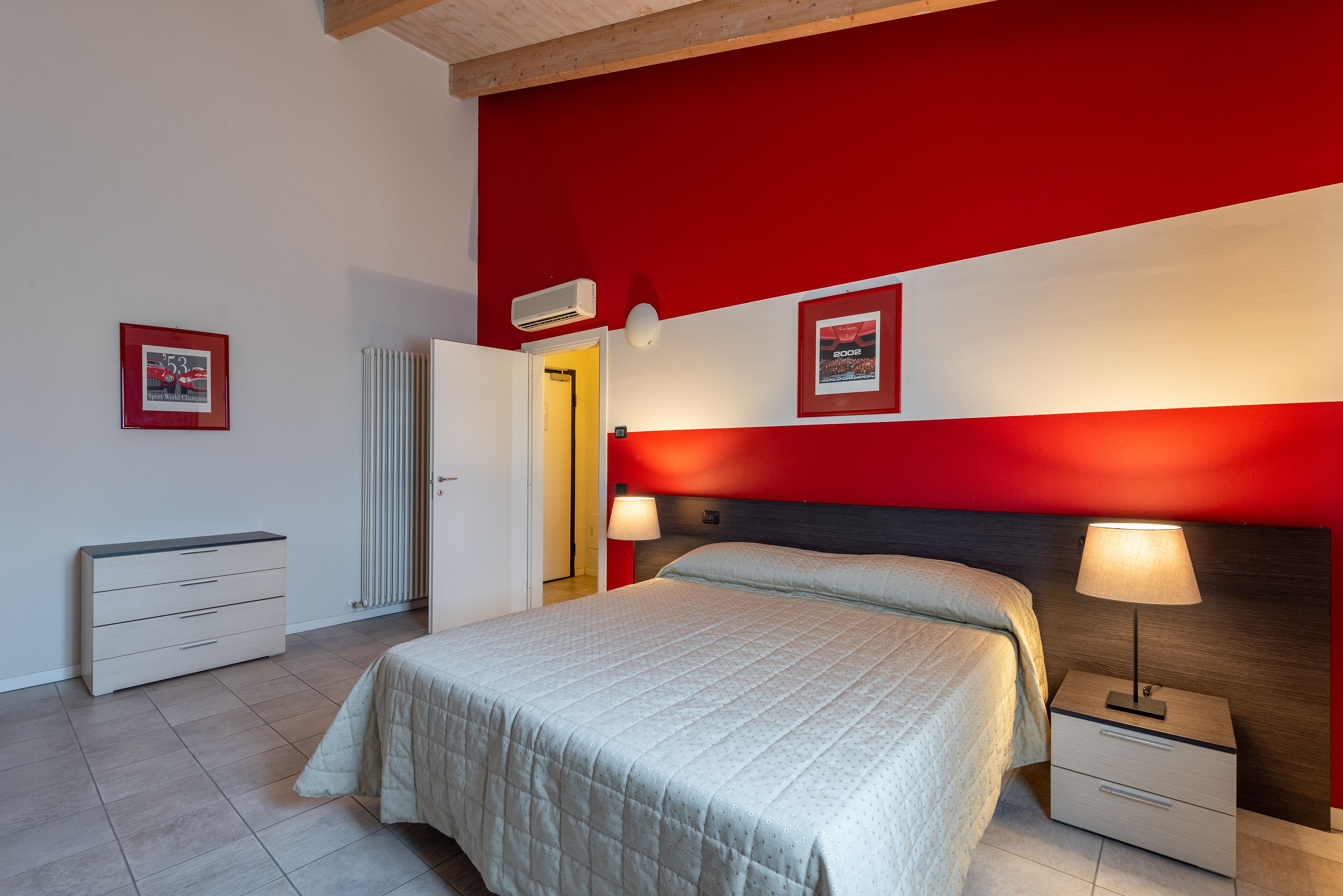 Ein Schlafzimmer mit Bett, Nachttischen, einem Schminktisch und einem Heizkörper.