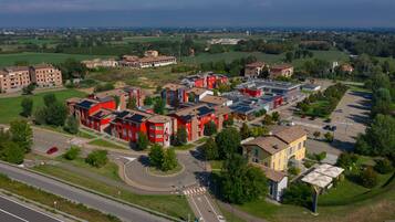 Vista aérea de uma área residencial com vários edifícios, estradas e campos verdes.