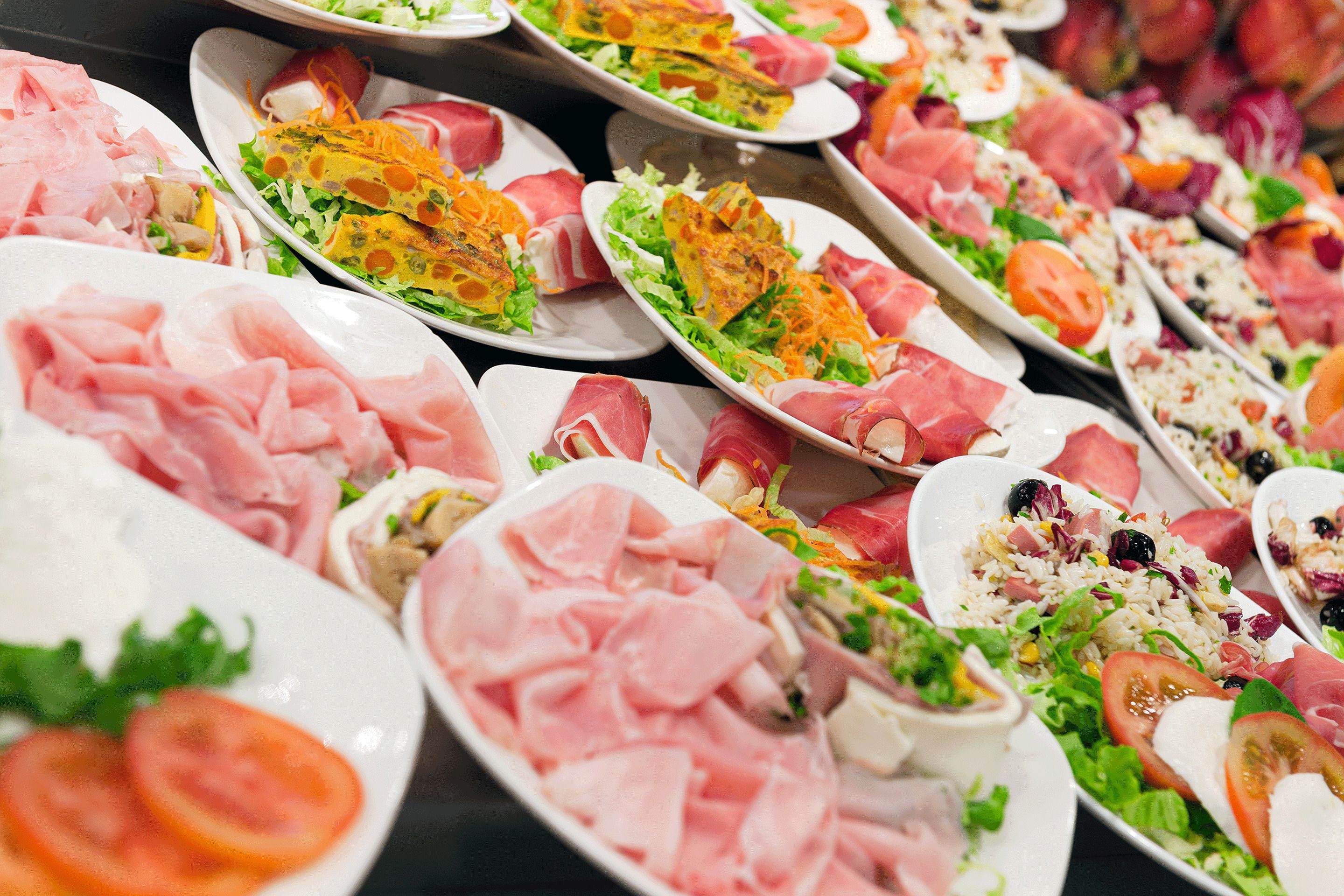 A buffet with various dishes including meats, salads, and rice.