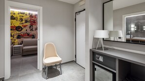 A modern bathroom with a large mirror, a vanity with a lamp, and a shower area. - Hotel Maranello Village (Maranello)
