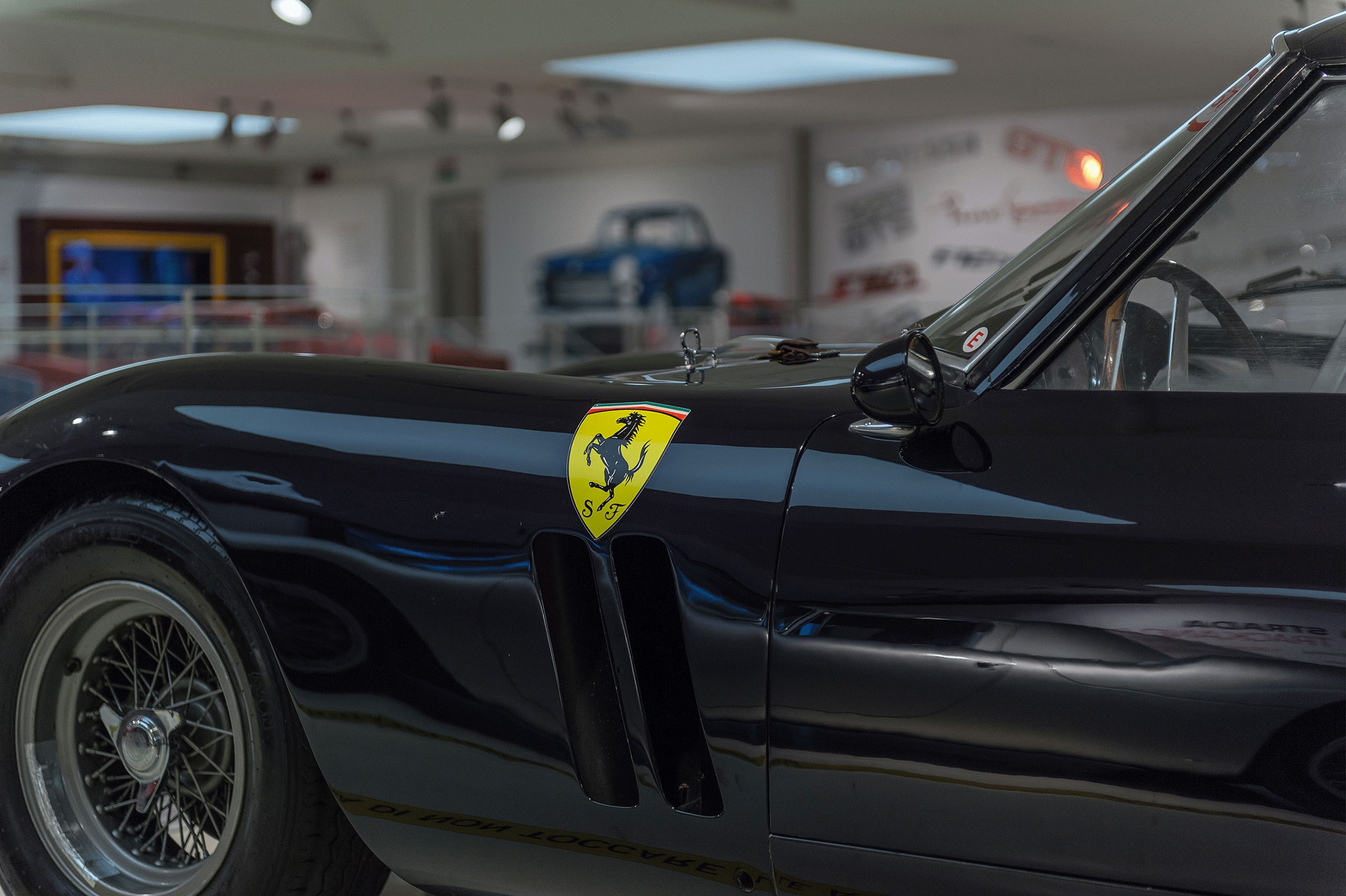 A black convertible with a visible Ferrari logo and a side mirror.