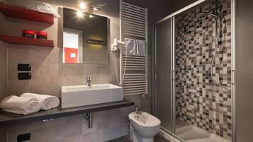 Un baño moderno con un lavamanos grande, un bidé y una ducha con pared de azulejos a cuadros.