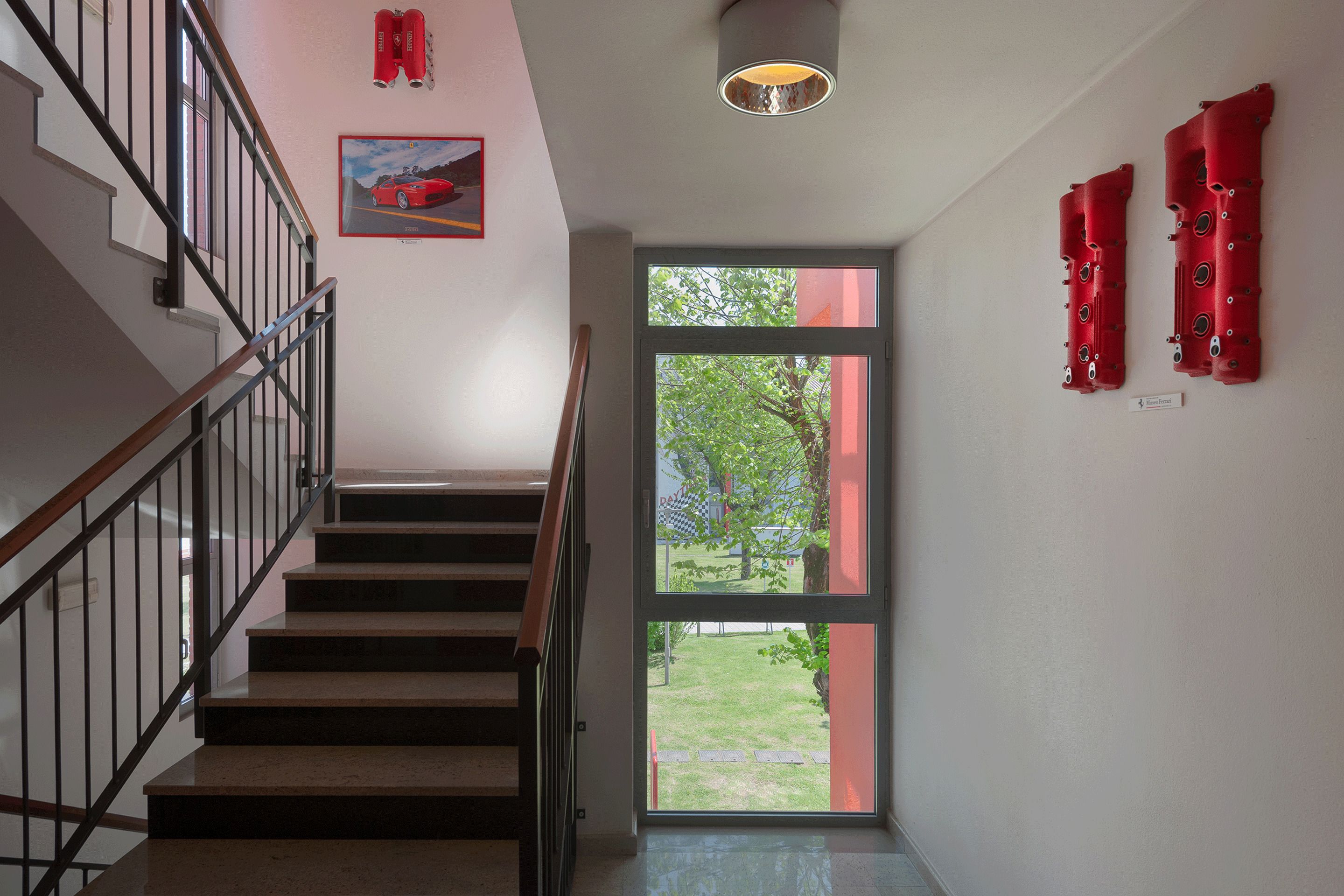 Una escalera conduce a un rellano con una puerta de vidrio que da al exterior.