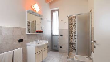 Un baño moderno con ducha, lavabo e inodoro.