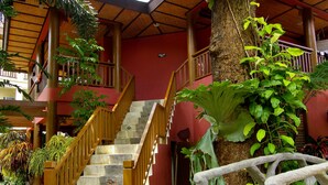 A staircase leading to a covered area with a tree and plants nearby. - Boracay Tropics Resort Hotel (Boracay Island)