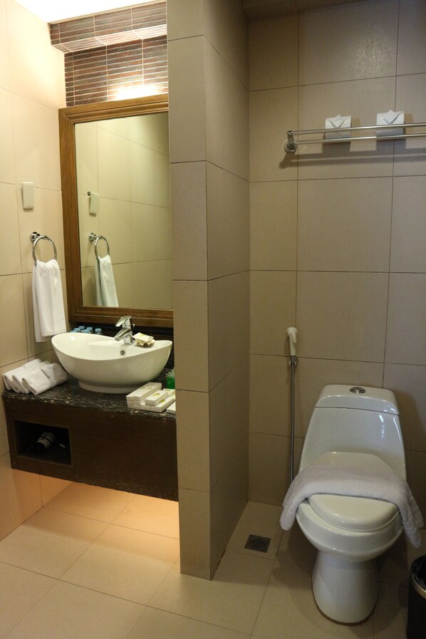 A bathroom with a sink, mirror, toilet, and towel rack.