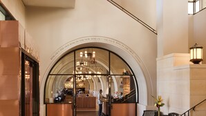 A spacious lobby with a high ceiling, a central arched window, and a bar area. - AT&T Hotel & Conference Center at the University of Texas (Austin)