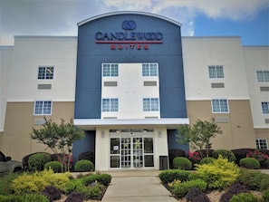 A hotel with a modern facade, a prominent signage for 'CANDLEWOOD SUITES,' and a well-maintained entrance with a pathway leading to the doors. - Candlewood Suites Macon by IHG (Macon)