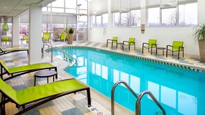 Zona de piscina con sillones de descanso y vistas al exterior.