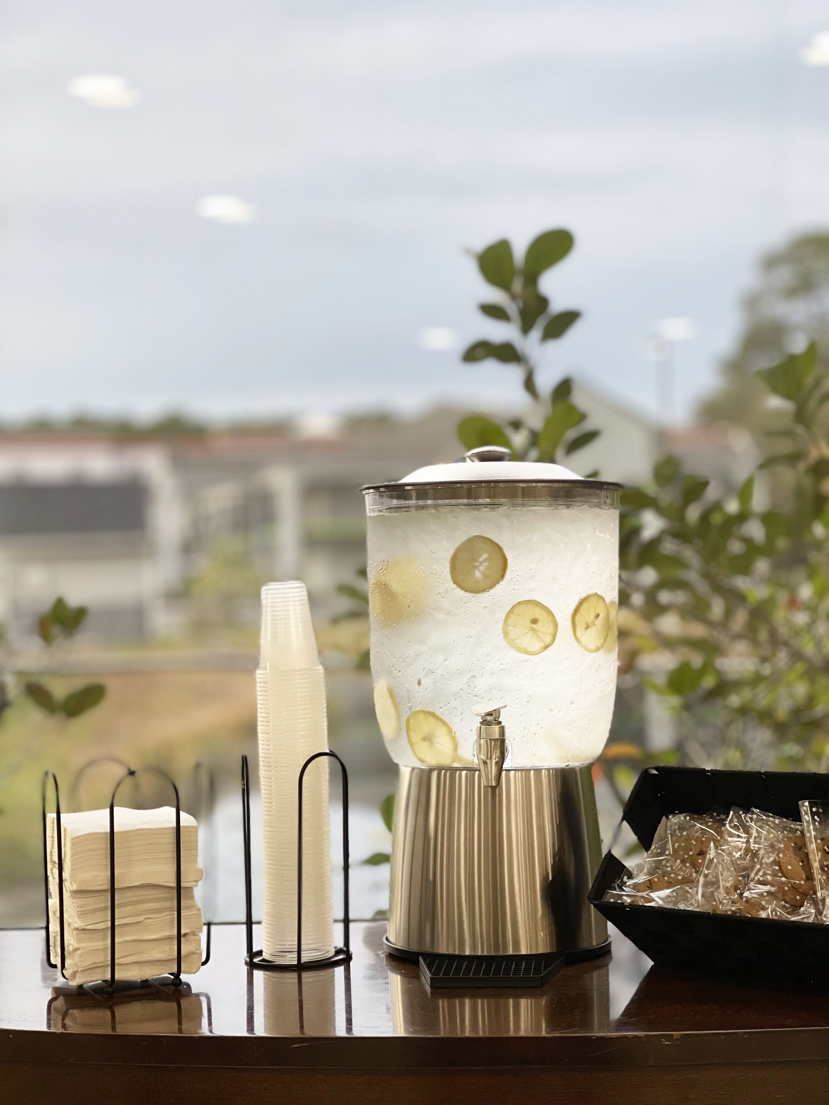 Un distributeur de boissons doté d’un récipient transparent, de glaçons et de rondelles de citron.