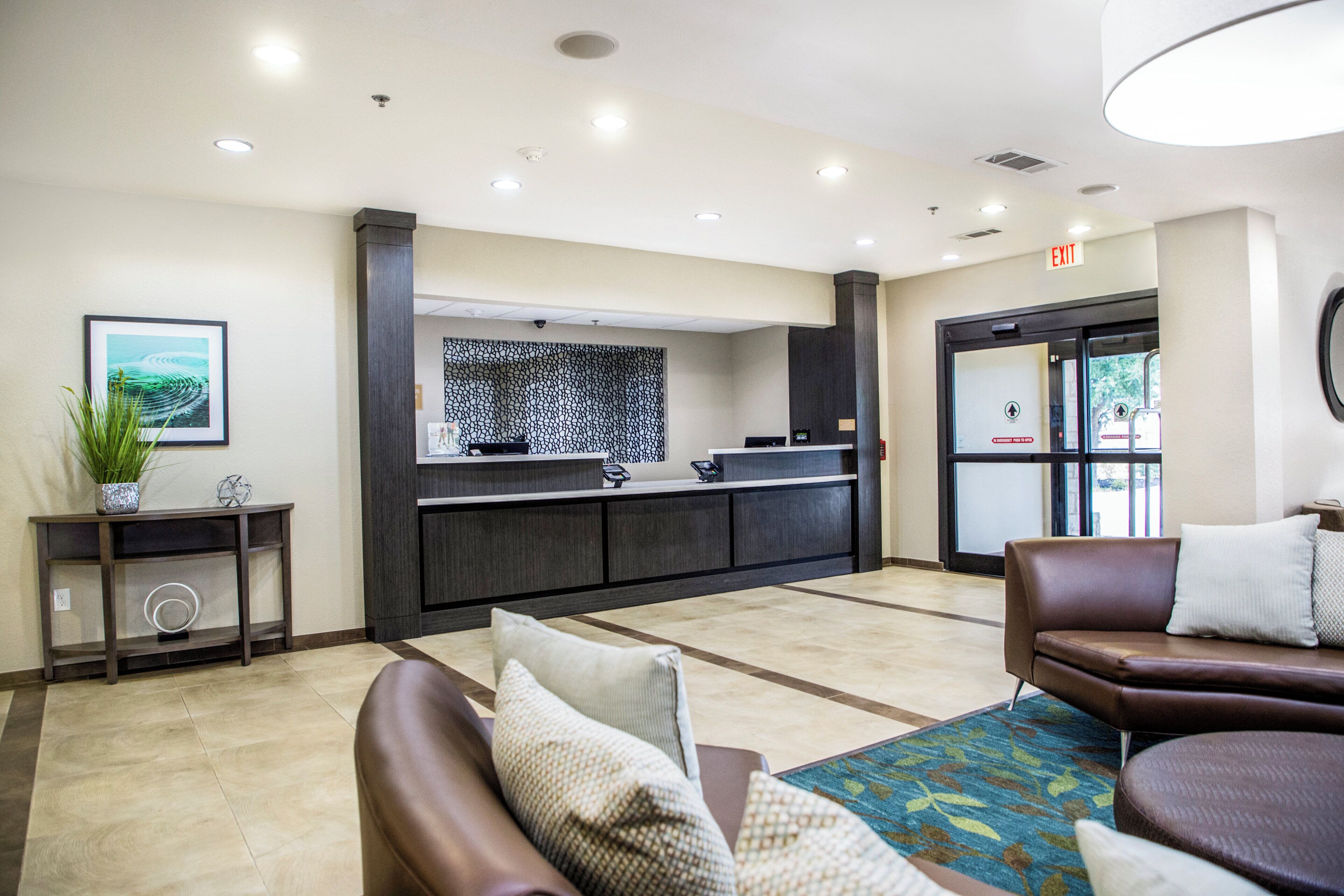 A reception area with a counter, seating, and a plant.