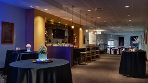 A hotel lobby with round tables, a bar area, and a seating arrangement. - Hilton Garden Inn Cleveland East/Mayfield Village (Mayfield)