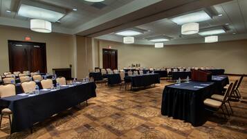 A conference room with tables and chairs, equipped with water bottles and nameplates.