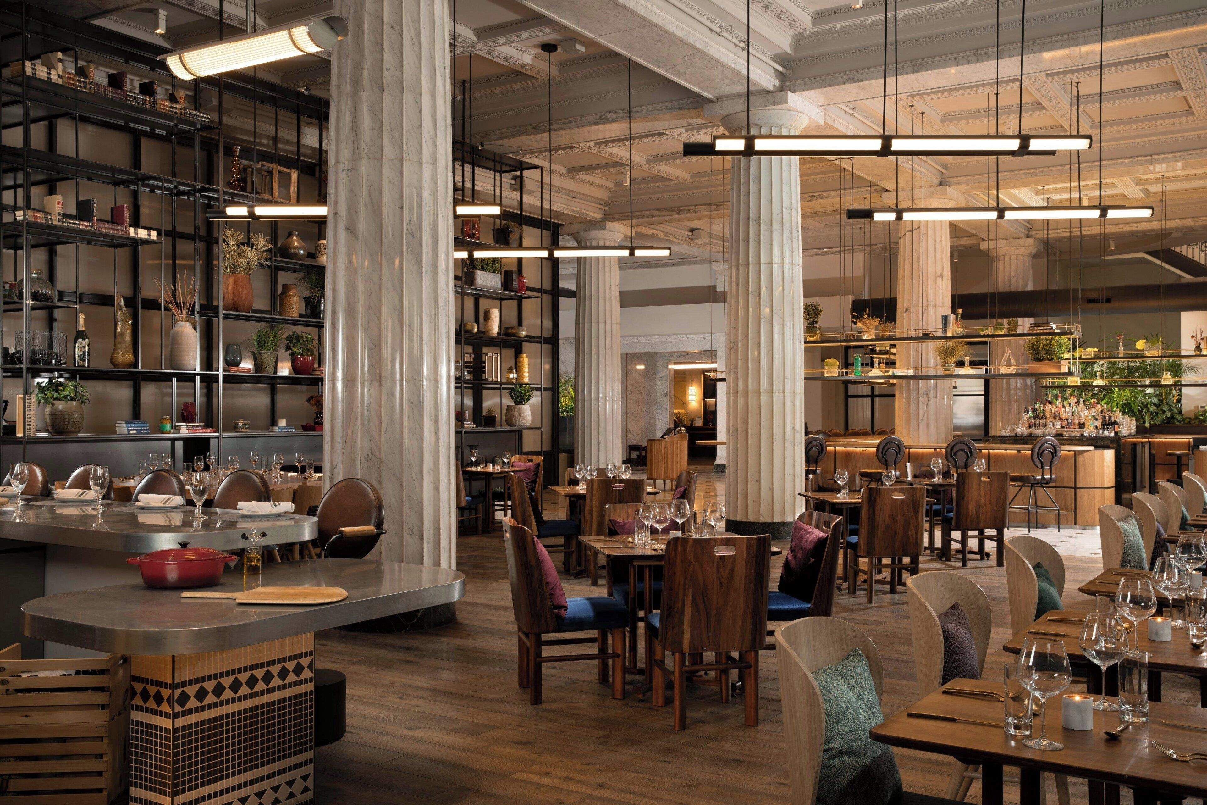 A spacious restaurant with high ceilings, exposed beams, and a variety of seating options including tables and booths.