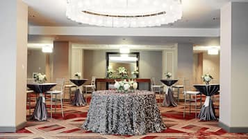 A conference room with a round table, chairs, and a chandelier.
