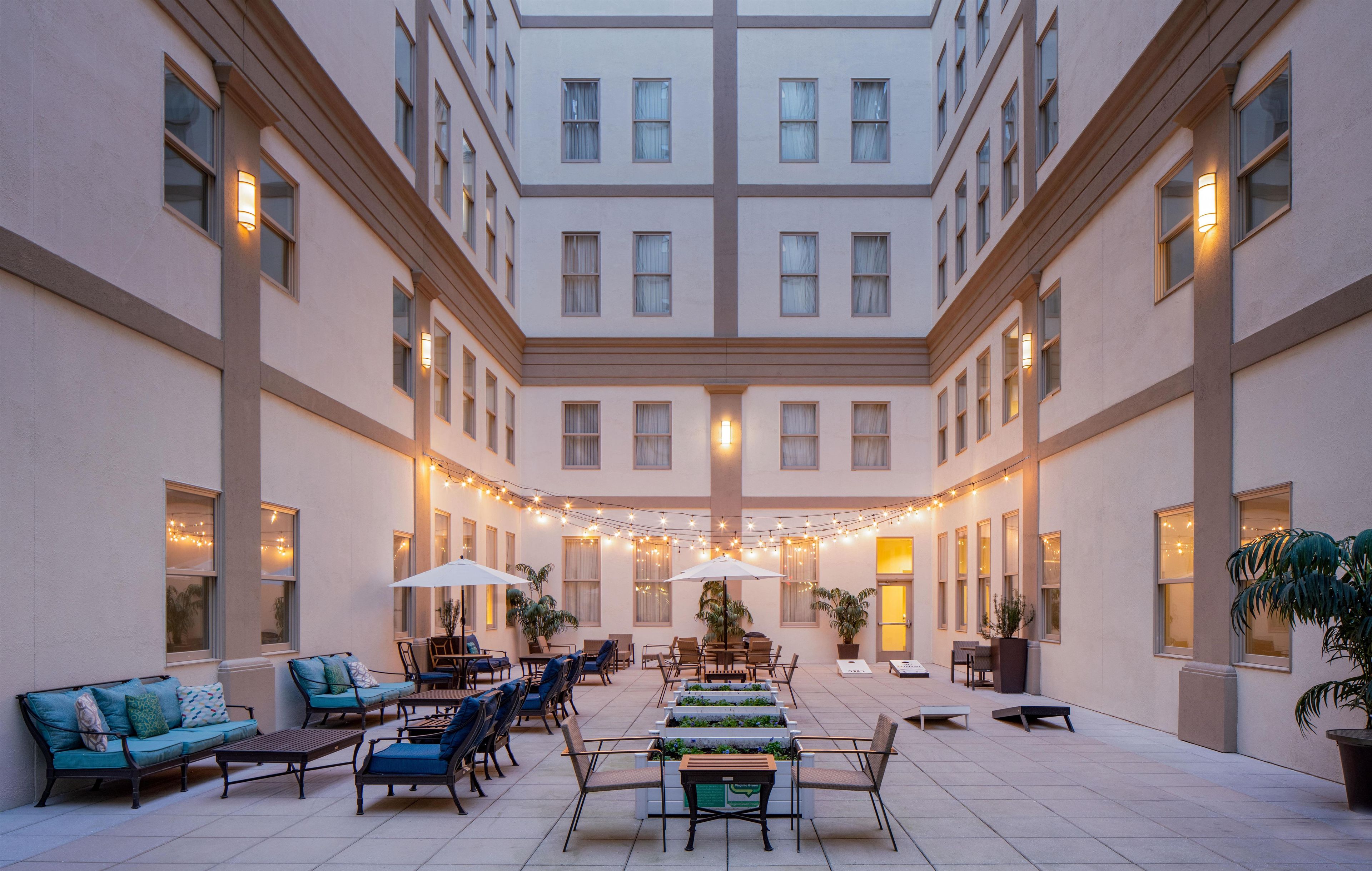A spacious outdoor patio with multiple seating areas, string lights, and potted plants.