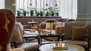 Una sala de estar moderna con un sofá, sillones, una mesa de centro y una estantería.