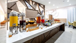 Een moderne ontbijtbalk met zelfbedieningsdrankautomaten, een fruitschaal en diverse ontbijtartikelen.
