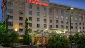 Un hôtel Hilton Garden Inn doté d’une façade moderne, de grandes fenêtres et d’un espace d’entrée abrité.