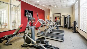 Une salle de sport équipée de tapis de course, de vélos elliptiques et de matériel de musculation.