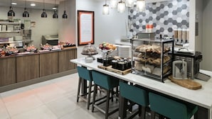 A modern breakfast bar with a variety of food items and a chalkboard menu.
