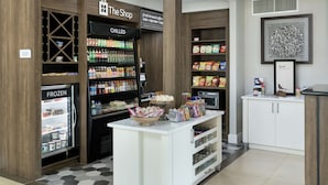 A coffee shop area with a refrigerated section, a chilled section, and a display of snacks and beverages.