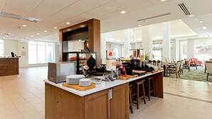 A spacious kitchen area with a central island, a waffle maker, and a coffee station. - Hilton Garden Inn Winchester (Winchester)