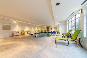 A pool area with chairs and a sign detailing pool rules. - Hilton Garden Inn Winchester (Winchester)