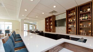 A modern kitchen with a long counter, built-in bar, and seating area. - Hilton Garden Inn Winchester (Winchester)