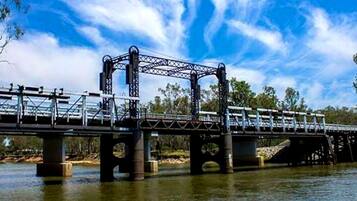 Un puente de acero con estructura de celosía cruzando un río.