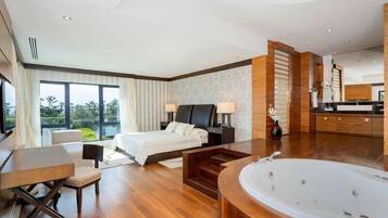 Una habitación de hotel moderna con una cama grande, una zona de estar, una bañera y vistas al exterior.