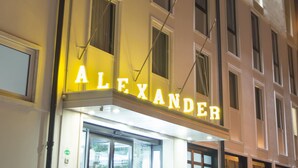 Un edificio con un letrero que dice “ALEXANDER” y varias ventanas.