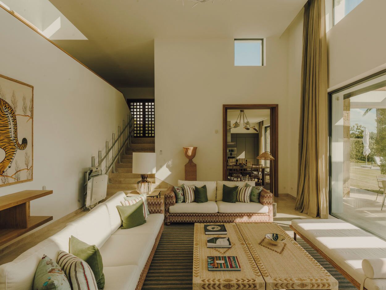 A modern living room with a sofa, coffee table, and a staircase leading to another level.